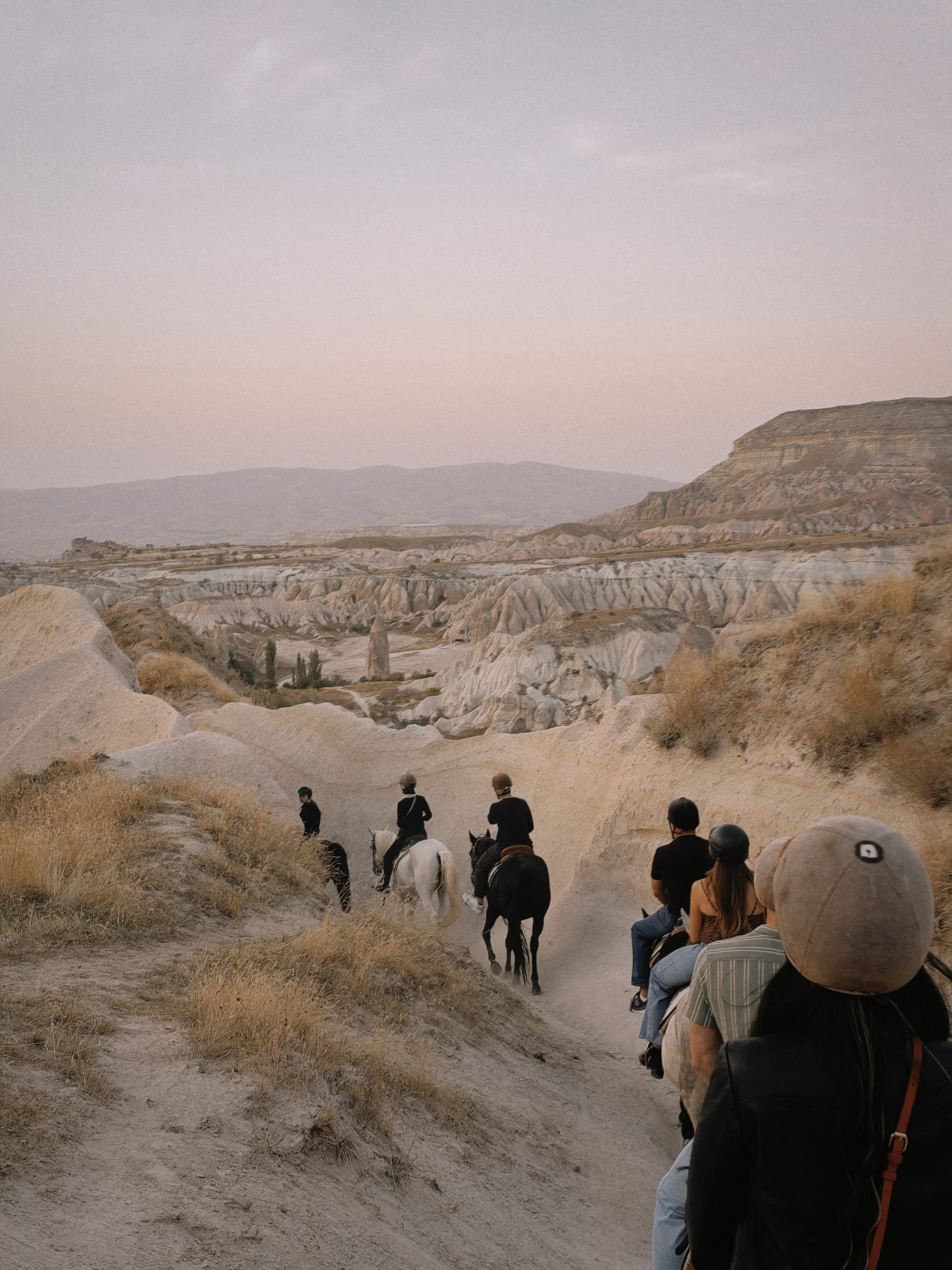 Horseback riding through a Cappadocia valley at sunset