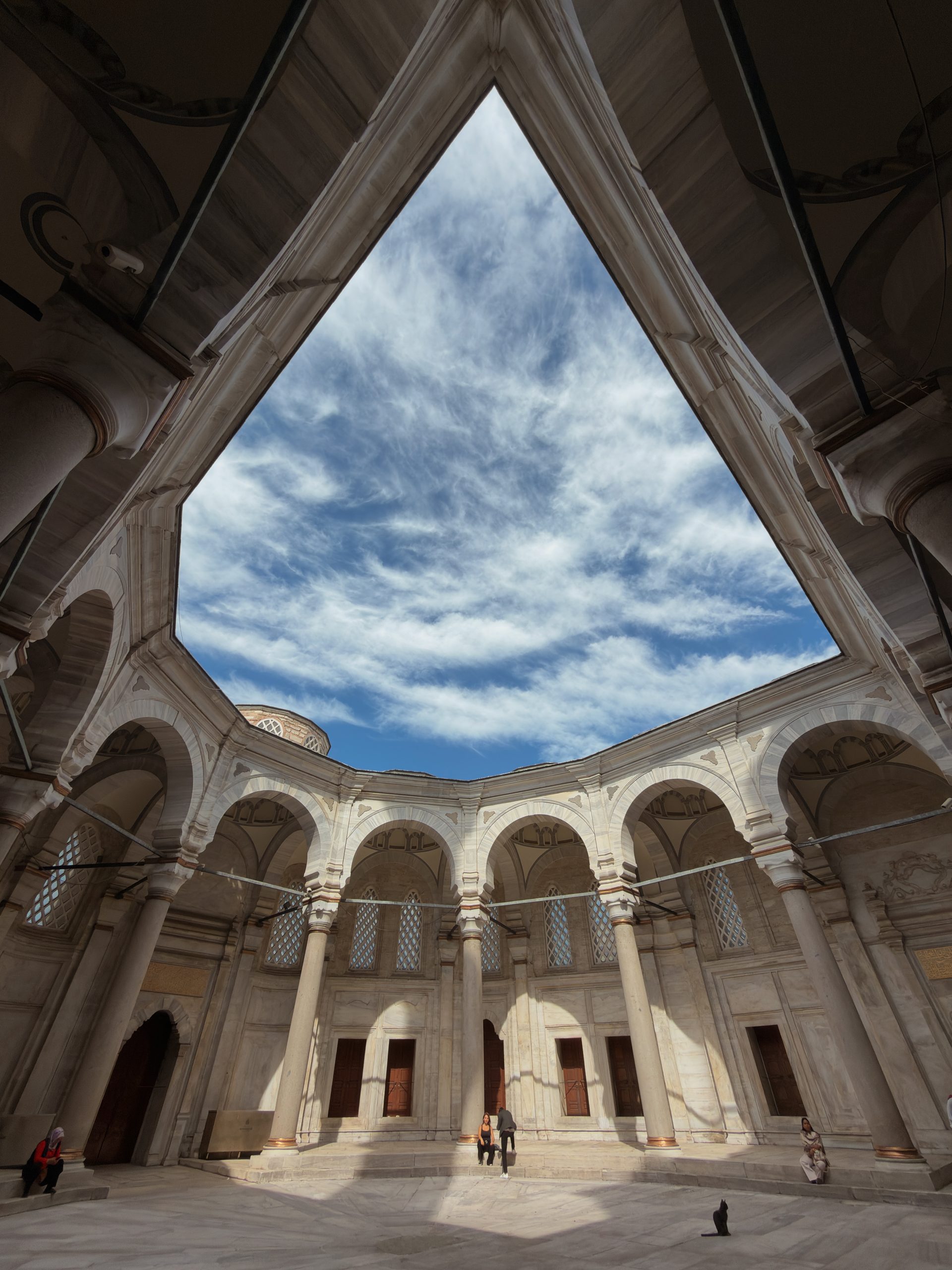 Ottoman courtyard arches beneath a blue Istanbul sky