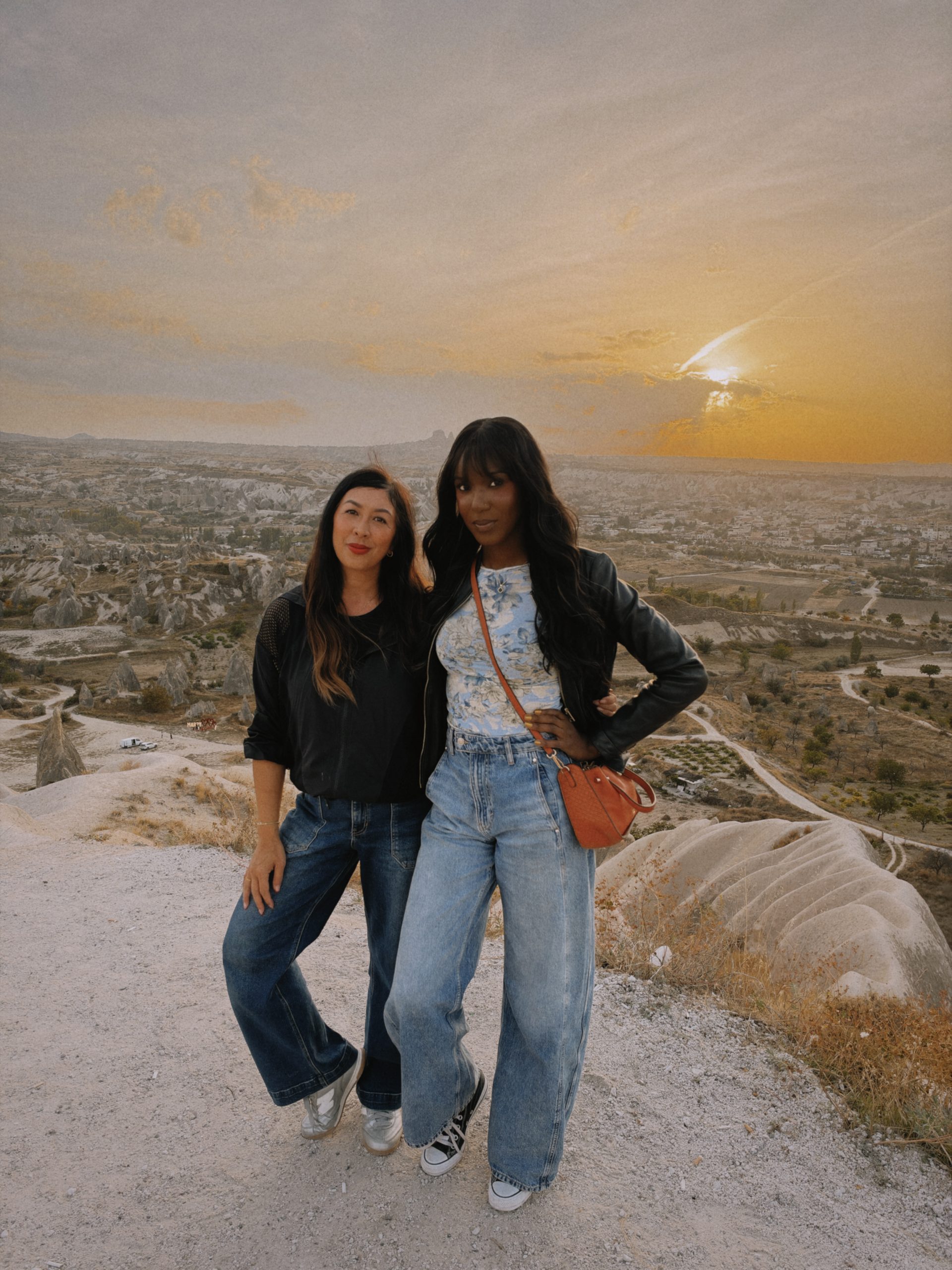 Two women overlooking the Cappadocia landscape at sunset