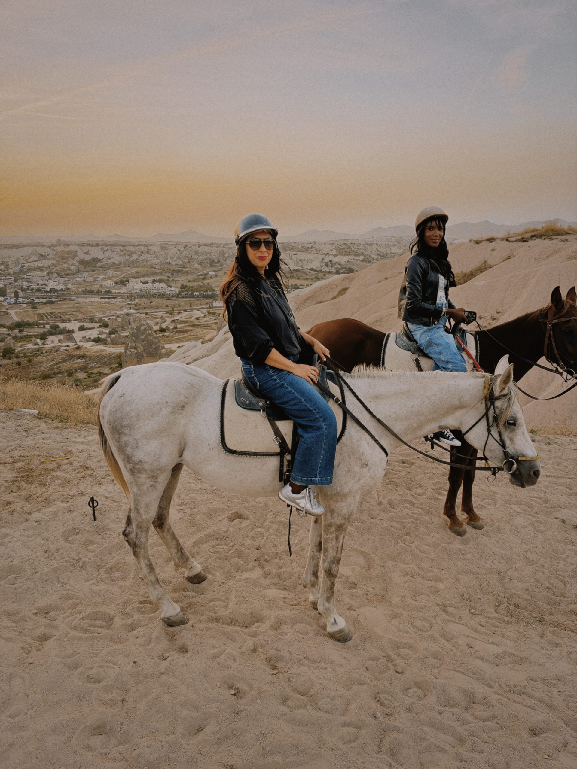 Two women horseback riding in Cappadocia at sunset